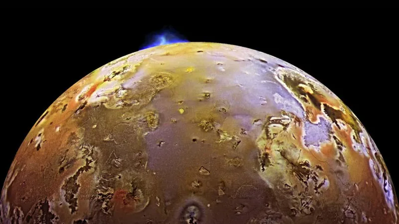 Synchronised volcanic eruptions on Io hint at a spongy interior